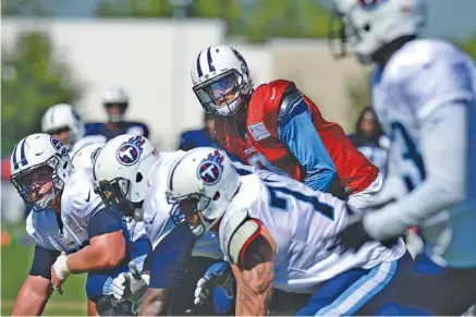  ?? THE ASSOCIATED PRESS ?? The Tennessee Titans’ offensive line takes pride in protecting quarterbac­k Marcus Mariota (in red).