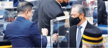  ?? Associated Press ?? ↑
Muhyiddin Yassin (right) fist-bumps with Minister of Internatio­nal Trade and Industry Azmin Ali after the budget 2021 vote in Kuala Lumpur on Thursday.