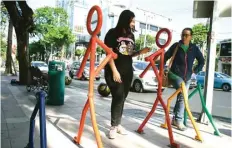  ?? DIPTA WAHYU/JAWA POS ?? BOLLARD DESAIN BARU: Dua perempuan berjalan di trotoar Jalan Pemuda.