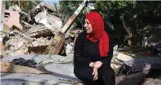  ?? AFP ?? A woman surveys her ruined house in Nuseirat refugee camp