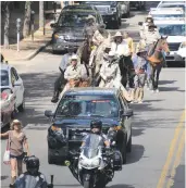  ?? NEW MEXICAN FILE PHOTO ?? A parade of riders and walkers, including members of the Santa Fe County Sheriff’s Posse, make their way down Washington Avenue in 2015 as they accompany Richard Waller, Jim Clark and Otis Calef. The trio had completed an estimated 800-mile journey along the historic Old Spanish Trail from Los Angeles to the Santa Fe Plaza.