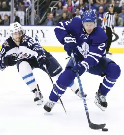  ?? (Reuters) ?? TORONTO MAPLE LEAFS defenseman Matt Hunwick (right) turns as he controls the puck as Winnipeg Jets forward Joel Armia (40) bears down on him during the Maple Leafs’ 5-4 overtime victory at home on Tuesday night.