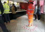  ?? FRANK AUGSTEIN - THE ASSOCIATED PRESS ?? People stand in marked places to keep a social distance at a fast food restaurant in London, Friday, March 20. For most people, the new coronaviru­s causes only mild or moderate symptoms, such as fever and cough. For some, especially older adults and people with existing health problems, it can cause more severe illness, including pneumonia.