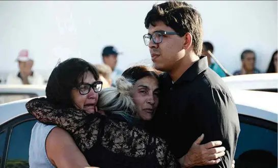  ??  ?? Viúva do vereador Adelmo Rodrigues de Melo (PSD), o Neguinho Boiadeiro, é consolada durante velório; ele foi baleado ao sair da Câmara de Batalha (AL)