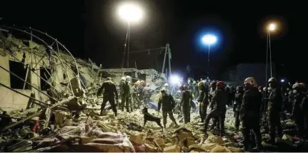  ??  ?? RESCUE OPERATION: Rescue teams pick through rubble on Saturday in the city of Ganja, Azerbaijan.