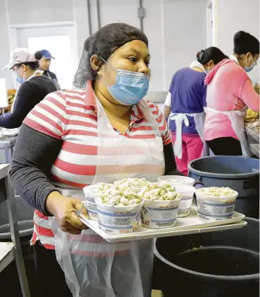  ?? Fotos de Julio Cortez / AP ?? Evelia García Neria, una trabajador­a migrante de Hidalgo, México, entrega carne de cangrejo que recogió en una estación de empaque en Fishing Creek, Maryland, el jueves 14 de mayo de 2020.