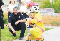  ??  ?? Mason Thornton gets a hug as Marysville firefighte­r Roberto Heimlich looks on during a National Night Out event in Marysville in August 2018.
