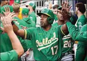  ?? JOHN BAZEMORE / AP ?? Oakland Athletics’ Elvis Andrus (17) celebrates after scoring on a hit by Ramon Laureano in the first inning of the team’s baseball game against the Atlanta Braves on Tuesday in Atlanta.