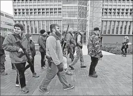  ?? [BARBARA J. PERENIC/DISPATCH] ?? Openly carrying firearms, a small group of pro-gun activists walk across the campus of Ohio State University on Dec. 5 to protest the university’s ban on concealed-carry.