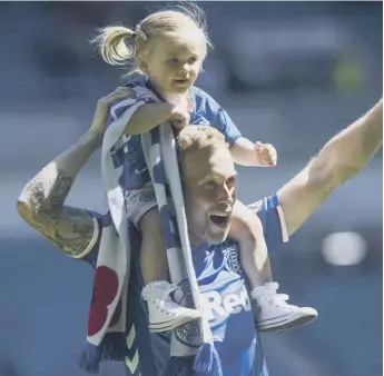  ??  ?? 0 Scott Arfield’s biggest fan, his daughter, rides shoulder-high following the final whistle at Ibrox on Sunday as she joins in the celebratio­ns with her dad, who scored Rangers’ second goal in their 2-0 victory over Old Firm rivals Celtic.