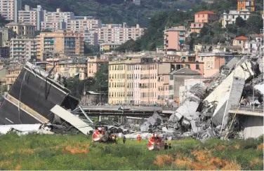  ?? Valery Hache / AFP / Getty Images ?? Rescuers look for survivors. Some 33 vehicles were on the span of the Genoa bridge that collapsed.