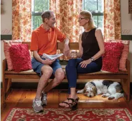  ??  ?? Ed and Terri take in the beautiful view of their property from a primitive handcrafte­d bench set in the dining area’s box bay window. Olive, their terrier mix, loves to be close by the couple.