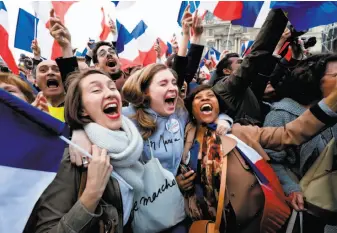  ?? Patrick Kovarik / AFP / Getty Images ?? Supporters cheer French president-elect Emmanuel Macron at the Louvre Museum in Paris. The centrist’s victory may have indicated that the populist wave has crested.