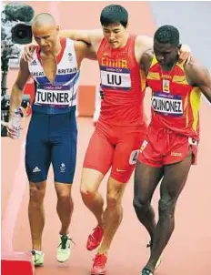  ??  ?? Crash and burn Xiang Liu of China is helped off by Britain’s Andrew Turner (left) and Jackson Quinonez of Spain.
EPA
