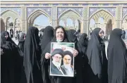  ?? AFP ?? Iranians hold portraits of Ayatollah Ruhollah Khomeini and Ayatollah Ali Khamenei as they queue to vote at the Shah Abdul Azim shrine on the outskirts of Tehran on Friday.