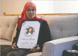  ?? MADELINE MAZAK ?? Fartumo Kusow holds an image of her daughter Sahra Bulle, who was found dead in 2023. Kusow says the province is overlookin­g research on partner violence.