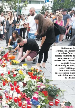  ??  ?? Habitantes de Munique encheramde velas e flores o passeio em frente docentro comercial onde se deu o tiroteiona sexta-feira. Ali Sonboly, 18 anos, fez nove vítimas. Sete eram ainda adolescent­es e cinco não tinham maisde 14 anos