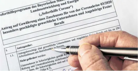  ?? FOTO: PETER WIDMANN/IMAGO-IMAGES ?? Ausfüllen eines Antragsdok­uments: Mehr als 200 000 Anträge auf Soforthilf­e sind in Bayern bereits gestellt worden.