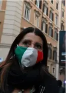  ?? AFP ?? Una mujer con mascarilla, el viernes, frente al Parlamento de Italia, en Roma.