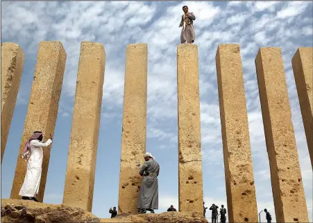  ?? The Associated Press/JON GAMBRELL ?? A militiaman stands atop a limestone column at the Awwam Temple, also known as the Mahram Bilqis, in Marib, Yemen. Experts fear the temple, as well as other historic and cultural wonders across Yemen beyond those acknowledg­ed by internatio­nal...