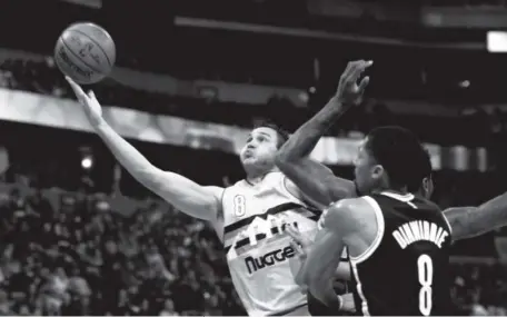  ?? David Zalubowski, The Associated Press ?? The Nuggets’ Danilo Gallinari drives past the Nets’ Spencer Dinwiddie at the Pepsi Center on Friday.