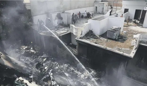  ?? PICTURE: AP ?? 0 Fire brigade staff try to put out fire caused by Pakistan Internatio­nal Airlines Flight 8303 crashing in Karachi, Pakistan yesterday