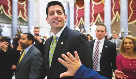  ?? AP ?? House Speaker Paul Ryan passes a waving tourist as he walks from the House Chamber to his office on Capitol Hill in Washington on Friday.