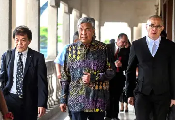  ??  ?? Ahmad Zahid (centre) arrives at the Sessions Court to face another CBT charge involving RM260,000 belonging to Yayasan Akalbudi. — Bernama photo