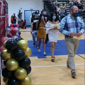  ?? RECORDER PHOTO BY ESTHER AVILA ?? PUSD Counselor Raul Bermudez escorts the graduating seniors into the gymnasium Friday, July 9. The seniors caught up on missing units during a district summer school held at Butterfiel­d Charter to graduate as the Class of 2021.