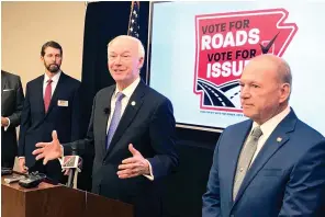  ?? Andrew DeMillo/Associated Press ?? ■ Arkansas Gov. Asa Hutchinson, center, speaks at a news conference Nov. 15, 2019, at the Poultry Federation in Little Rock about the campaign to extend a half-cent sales tax for highways. Hutchinson on Wednesday called the effort to keep the tax his top priority among this year’s ballot initiative­s.