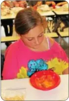  ??  ?? Manor Elementary School student Brooke Nicol looks at her half-completed landfill.