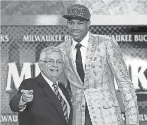  ?? ASSOCIATED PRESS ?? Former commission­er David Stern stands with Giannis Antetokoun­mpo, who was selected by the Bucks in the first round of the 2013 draft.