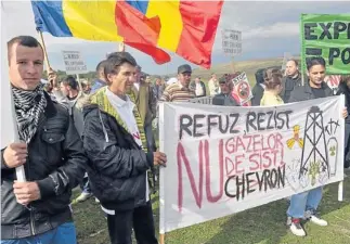  ?? AFP ?? Protesters hold a banner that reads ‘I refuse, I resist to shale gas, No to Chevron’’ during a protest against the exploitati­on of shale gas in the village of Gagesti (300 kilometres northeast from Bucharest), Romania on September 15.