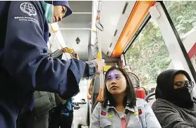  ?? FRIZAL/JAWA POS ?? ANTISIPASI DI PINTU MASUK: Petugas memeriksa suhu tubuh penumpang Suroboyo Bus kemarin (5/3).