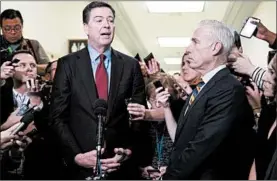  ?? ALEX EDELMAN/GETTY-AFP ?? Former FBI Director James Comey, center, talks to reporters after testifying in a closed hearing before House investigat­ors dealing with investigat­ions he oversaw.
