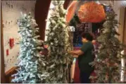  ?? CHAD FELTON — THE NEWS-HERALD ?? Rosemary Krupar “fluffs” a tree on Nov. 7, setting up one of the many decorative elements of Penitentia­ry Glen’s annual winter exhibit, “Candy Land has gone Wild!”