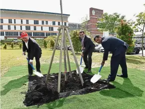  ??  ?? (From left) Kamarudin, George and Fernandes plant a symbolic rainbow gum tree at ECiM to mark the launch of the scholarshi­p.