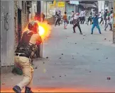  ?? PTI ?? ▪ A policeman fires a tear gas shell towards the protesters hurling stones at forces in Srinagar on Saturday.