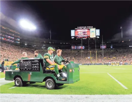  ?? ADAM WESLEY / USA TODAY ?? Packers quarterbac­k Aaron Rodgers is taken off the field after sustaining a knee injury in the second quarter against the Bears. The Packers scored 24 points in the second half after Rodgers returned in their 24-23 victory.