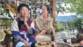  ?? ?? He Cuiying (left) and her granddaugh­ter, He Qingmei, chant Tibetan Buddhist prayers in Qibie village, Yunnan province.