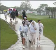  ?? MARTA LAVANDIER — THE ASSOCIATED PRESS ?? Spectators exit the course as heavy rain delays the final round of the Cognizant Classic on Sunday in Palm Beach Gardens, Fla.