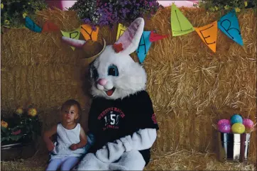  ?? PHOTOS BY KIMBERLY K. FU — THE REPORTER ?? Olivia Figueroa, 2, of Suisun City poses with the Easter Bunny at Western Ranch in Vacaville. Her dad, Tyler, said they missed out on the photo op last year due to the pandemic and jumped at the chance to meet the iconic critter on Saturday.