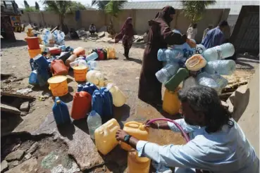  ?? AP PHOTO/FAREED KHAN ?? People get drinking water from a slum well Tuesday in Karachi, Pakistan.