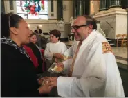  ?? SUBMITTED PHOTO ?? The Rev. Gus Puleo, right, seen here giving out blessed bread to parishione­rs after the Thanksgivi­ng Day Mass, served as a deacon to the new Archbishop.