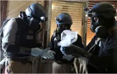  ??  ?? File photo of a United Nations chemical weapons expert, wearing a gas mask, holds a plastic bag containing samples from one of the sites of an alleged chemical weapons attack in the Ain Tarma neighbourh­ood of Damascus, Syria. — Reuters photo