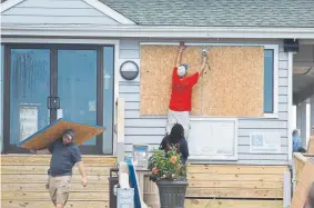  ?? Matt Born, The StarNews ?? Crews board up the Oceanic restaurant in Wrightsvil­le Beach, N.C., on Tuesday in preparatio­n for the arrival of Hurricane Florence.