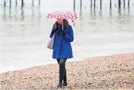  ??  ?? Winter warmer...a woman walks on Brighton beach in ‘sunny’ February