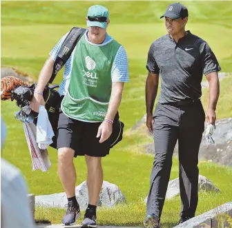  ?? STAFF PHOTO BY CHRIS CHRISTO ?? LOVELY AFTERNOON STROLL: Tiger Woods and caddie Joe LaCava make their way to the 17th green at TPC Boston during the first round of the Dell Technologi­es Championsh­ip yesterday in Norton.