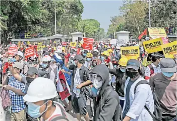  ??  ?? Students come out from Yangon University after the gate was opened as they protest against the military coup in Yangon