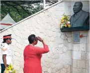  ??  ?? Olivia Grange (right), minister of entertainm­ent, sport, culture and gender affairs, salutes the Marcus Garvey cenotaph before laying a wreath yesterday. Looking on is Woman Corporal Danesha McEachon.